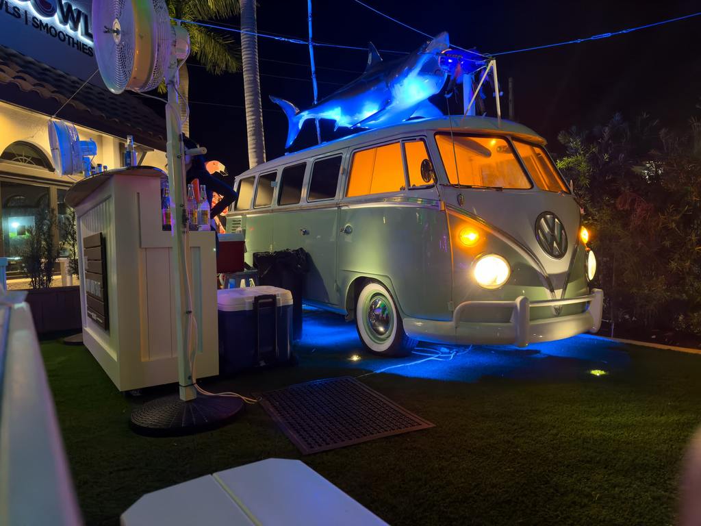 VW van with blue lights and a shark on top